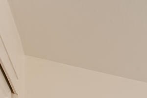 Apartments in Lake Oswego, OR, for Rent - Westlake Meadows - Bedroom with a Bed, Layered Bedding, Wall Art, Bedside Tables, Lamps, a Floor Mirror, and a Potted Plant.